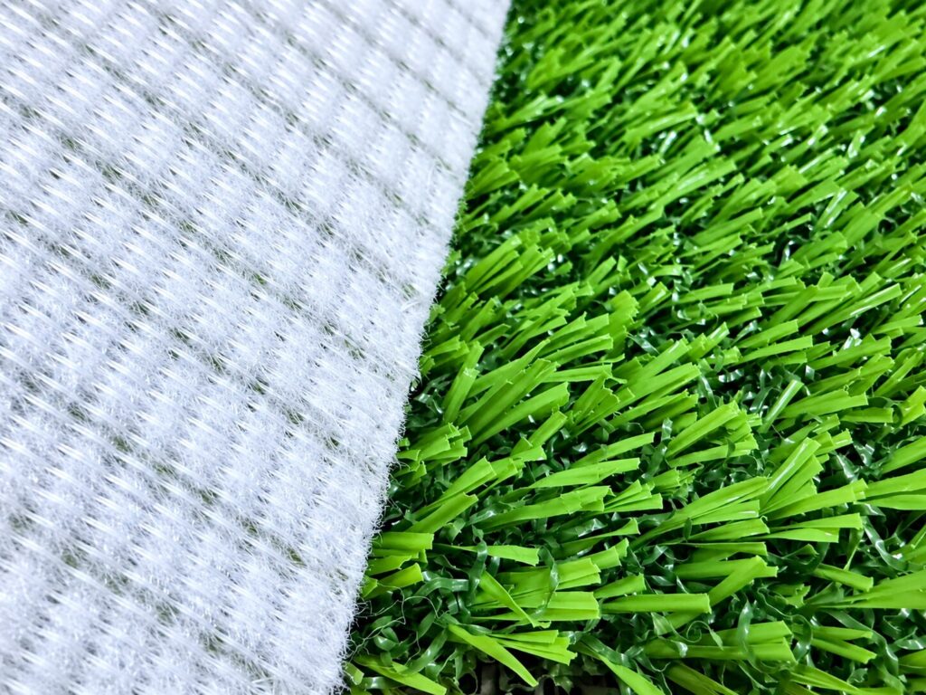 Folded pet artificial grass roll showing non-woven backing